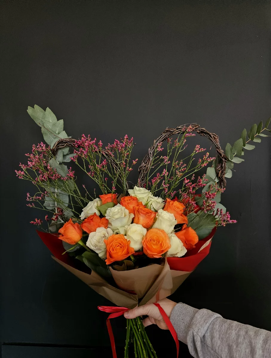 Elegancki bukiet z pomarańczowych i białych róż z ozdobnym sercem z wikliny na ciemnym tle, Bydgoszcz