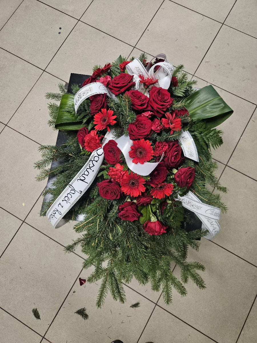 Tradycyjny wieniec pogrzebowy na podkładzie z jedliny z czerwonymi różami i białą szarfą, Bydgoszcz